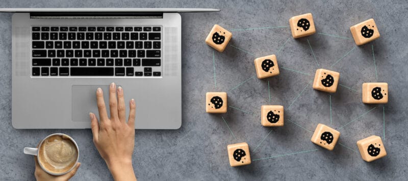 Cookie blocks next to a laptop - Google again postponing the demise of cookies