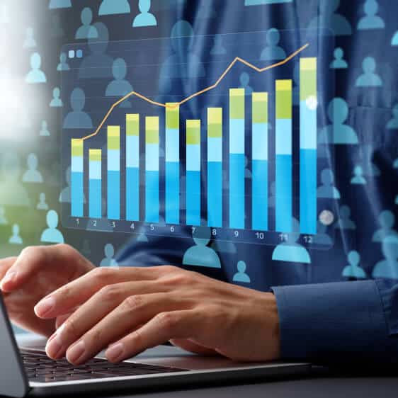 Businessman using laptop with graph on screen.